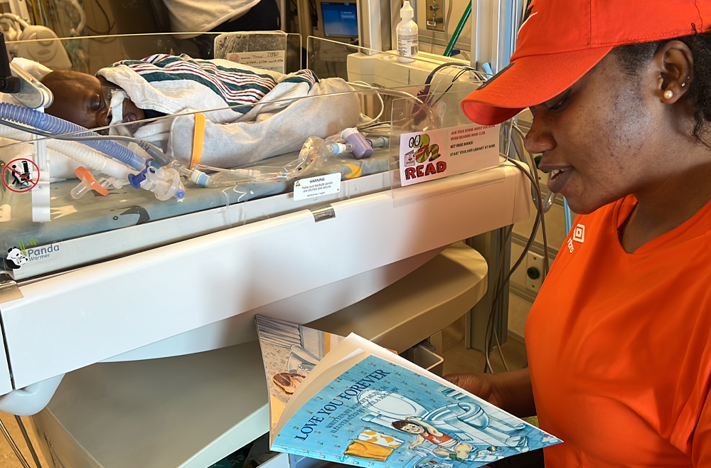 Boura Zerbo sits beside her baby’s incubator at the HUP Intensive Care Nursery and reads him a book.
